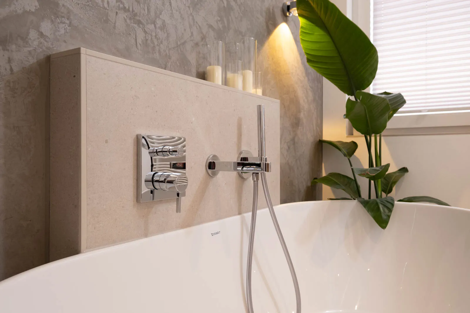 Detailaufnahme einer modernen Wandarmatur an einer freistehenden Badewanne.