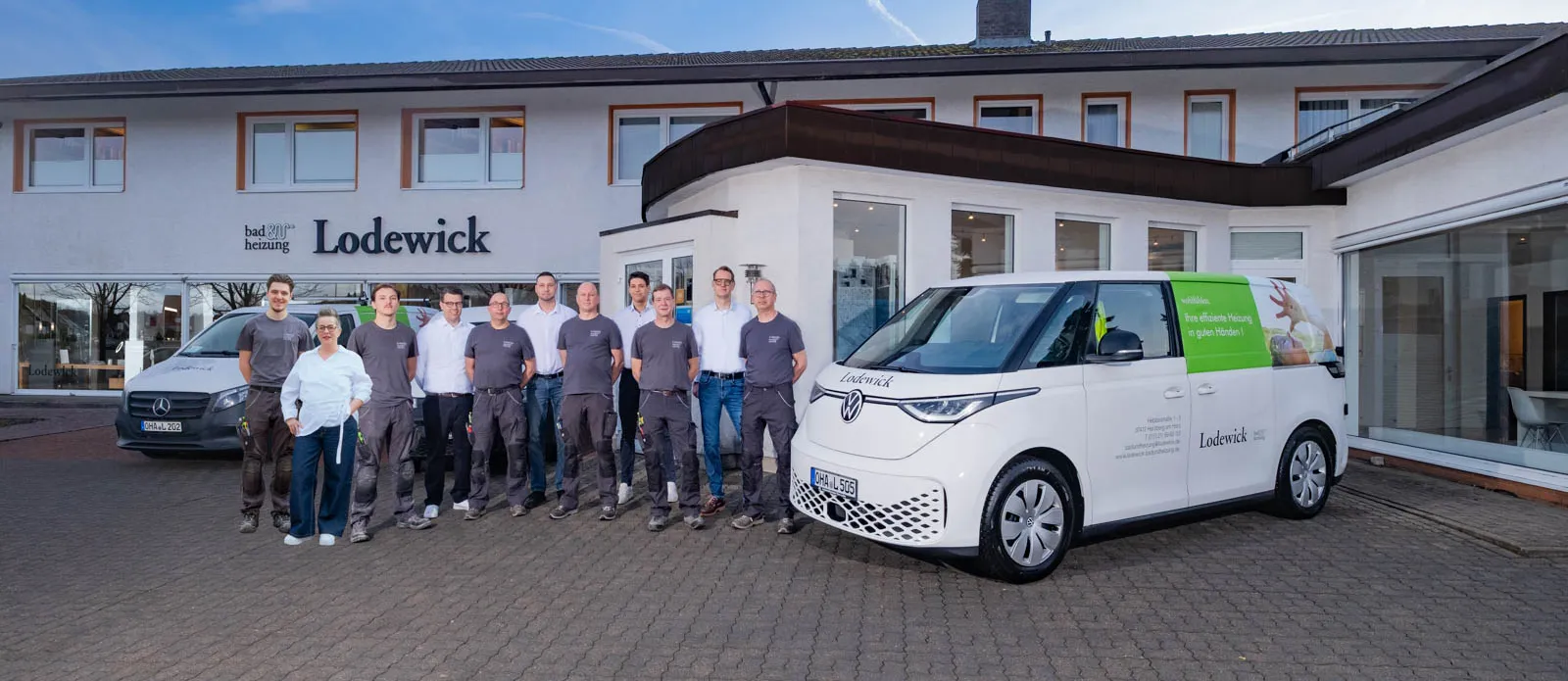 Das Lodewick-Team mit einem VW ID Buzz vor dem Firmengebäude.