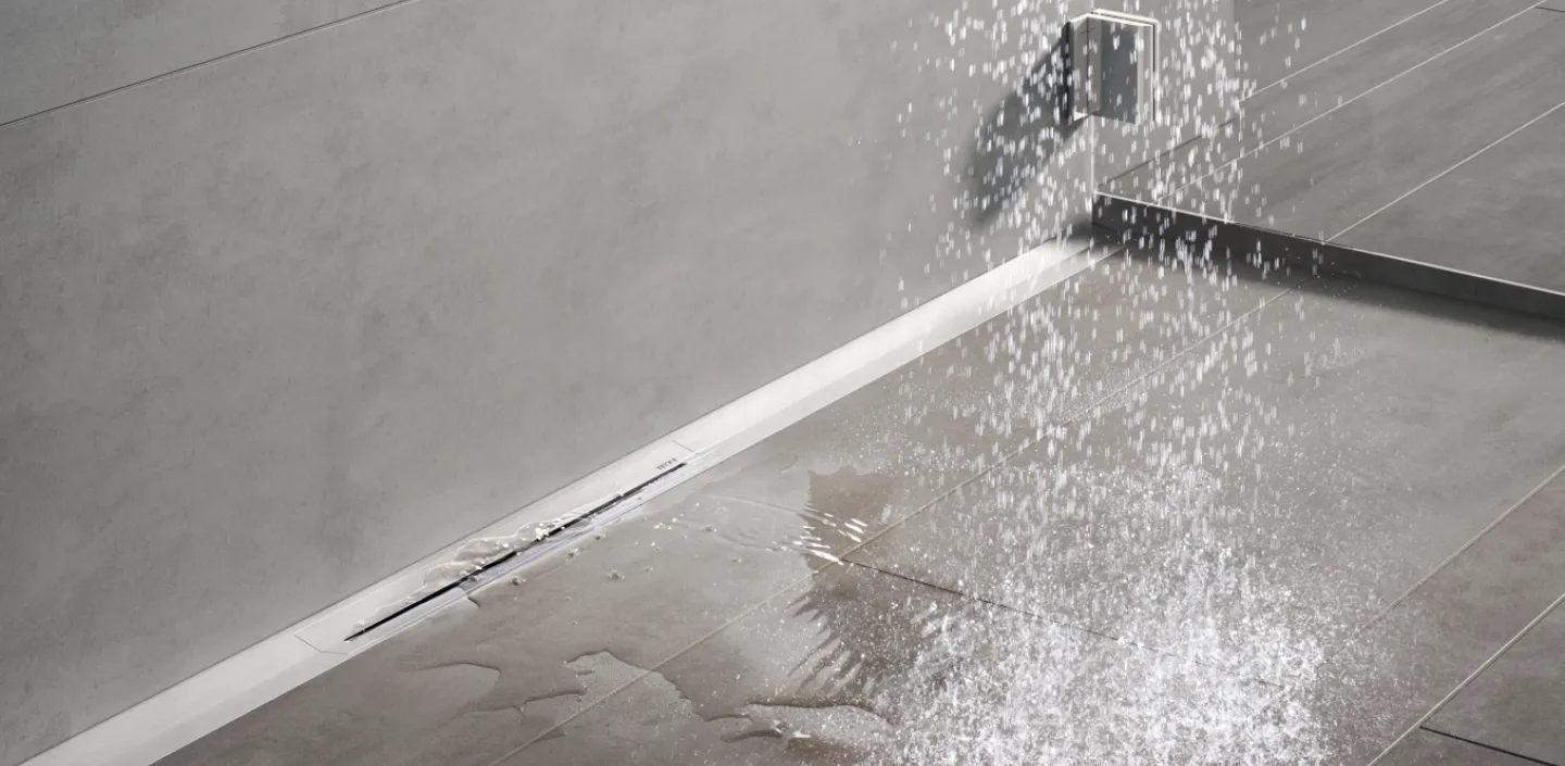 Die Ablaufrinne Drainline von TECE in einer bodenebenen Dusche mit Wasser.
