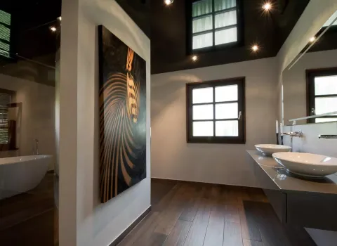 Badezimmer mit Holzboden und dunkler Lackspanndecke mit integrierten Strahlern.  Modern und mit glanz