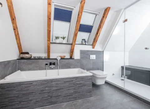 Bad mit Badewanne, wandhängendem WC und Glasdusche.