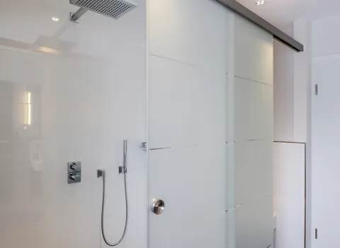 Begehbare Dusche mit Regendusche und matter Glasschiebetür.