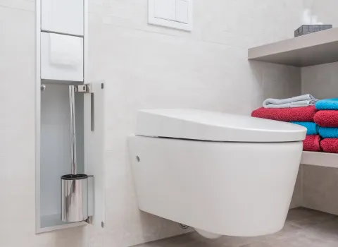 Wandhängendes WC mit Ablage, Handtüchern und Dachfenster im modernisierten Badezimmer.