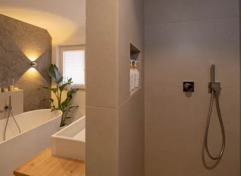 Begehbare Dusche mit integrierter Nische und modernen Armaturen im Bad.