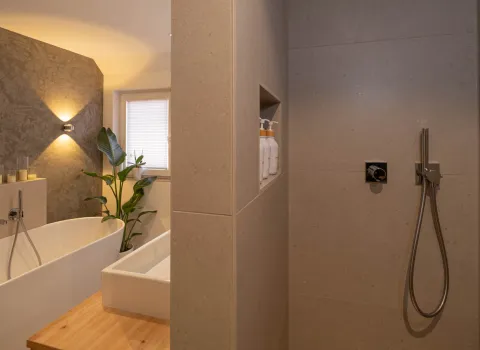 Begehbare Dusche mit integrierter Nische und modernen Armaturen im Bad.