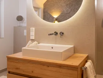 Duschbereich mit eingelassener Nische und stilvollen Pflegeprodukten.