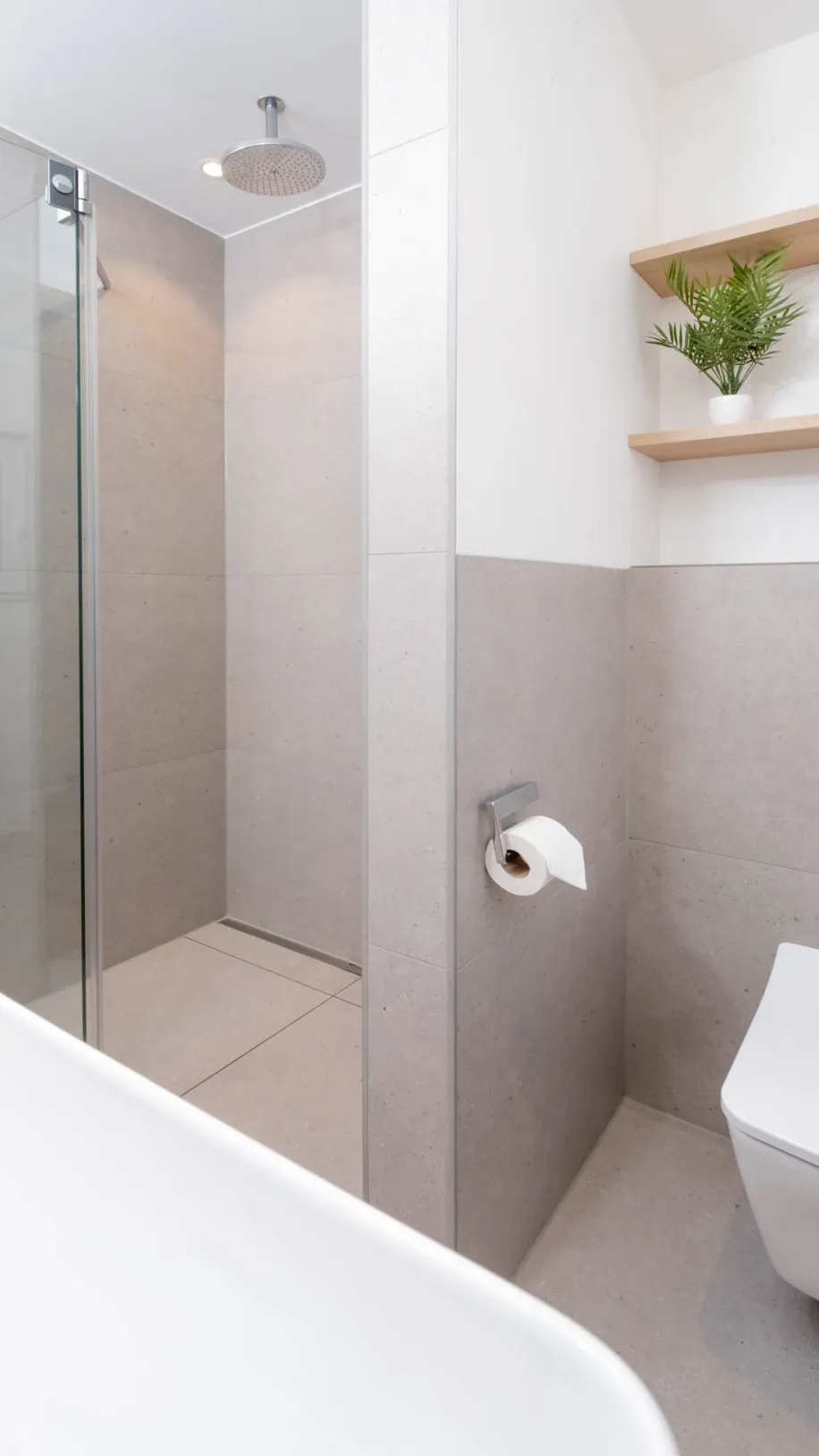 Modernes Badezimmer mit wandhängendem WC, Regendusche und Holzablage.