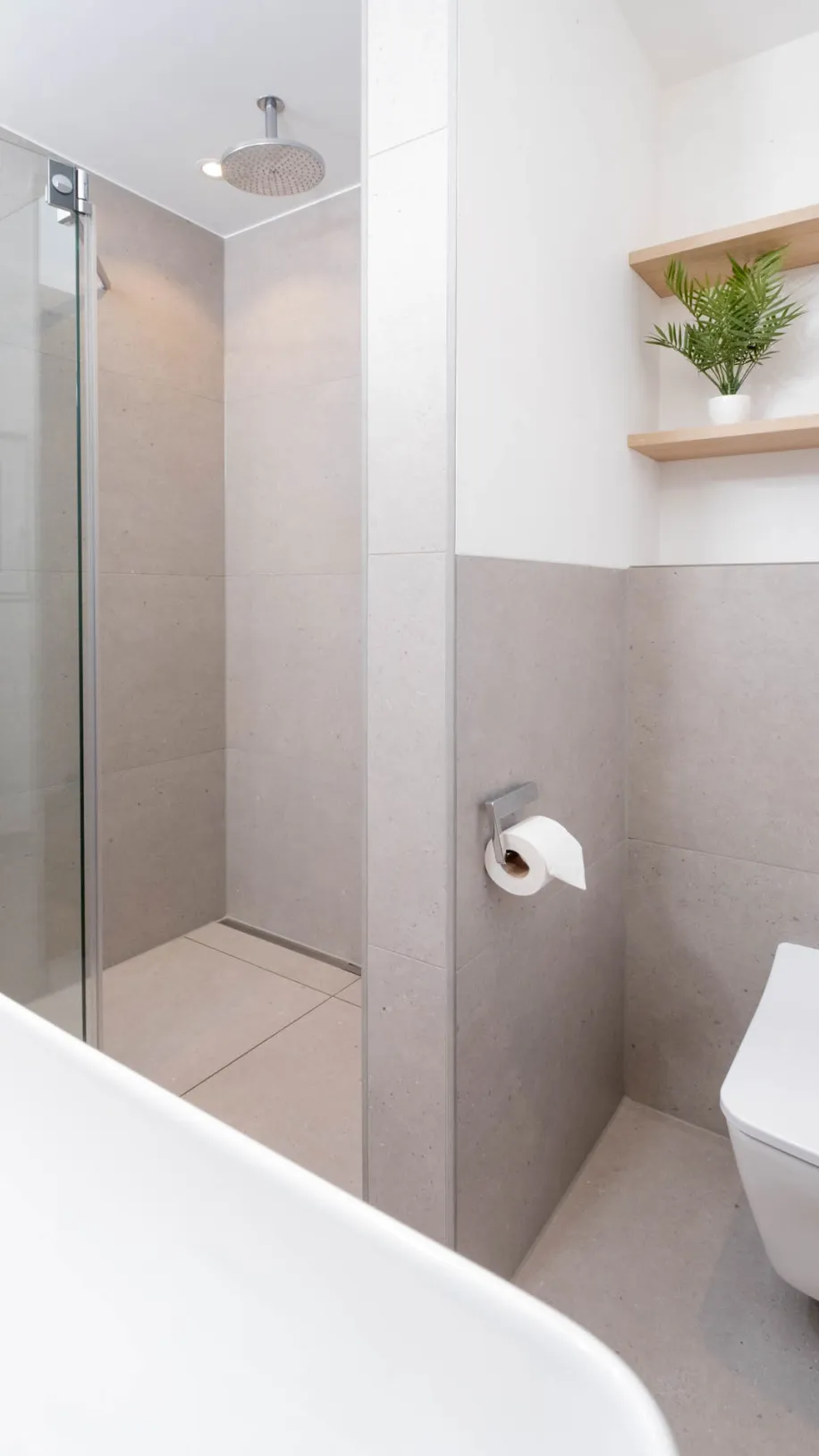 Modernes Badezimmer mit wandhängendem WC, Regendusche und Holzablage.